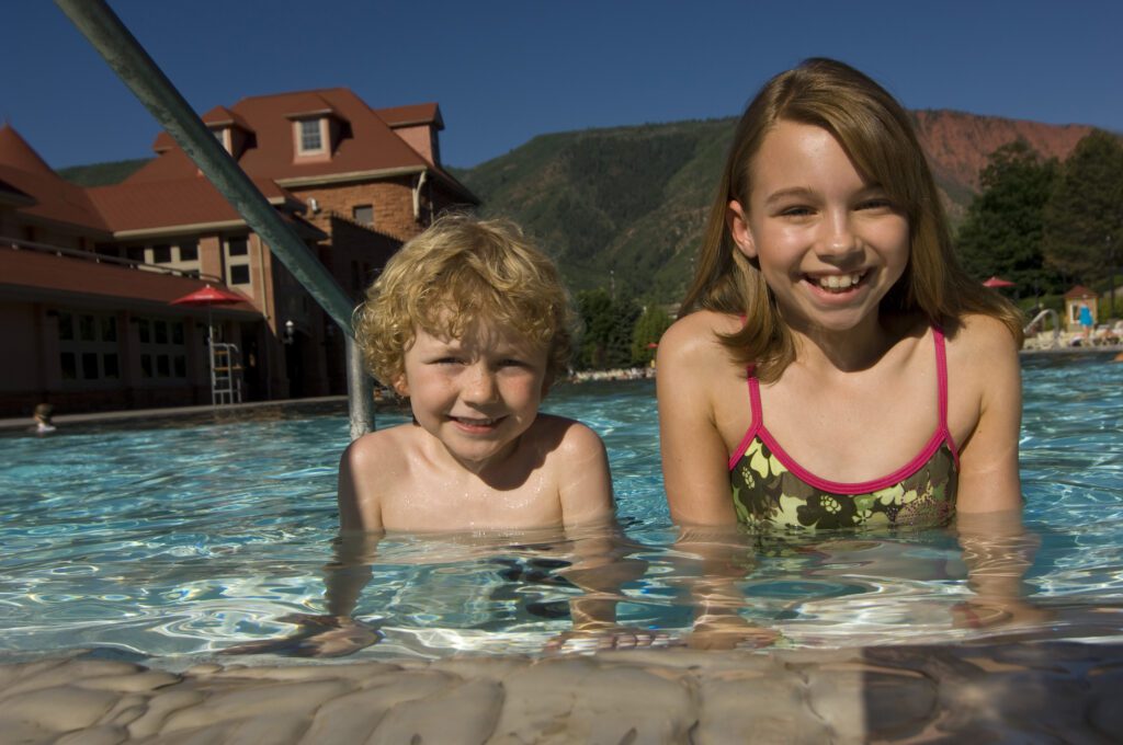 Two children at edge of Grand Pool at Glenwood Hot Springs Resort