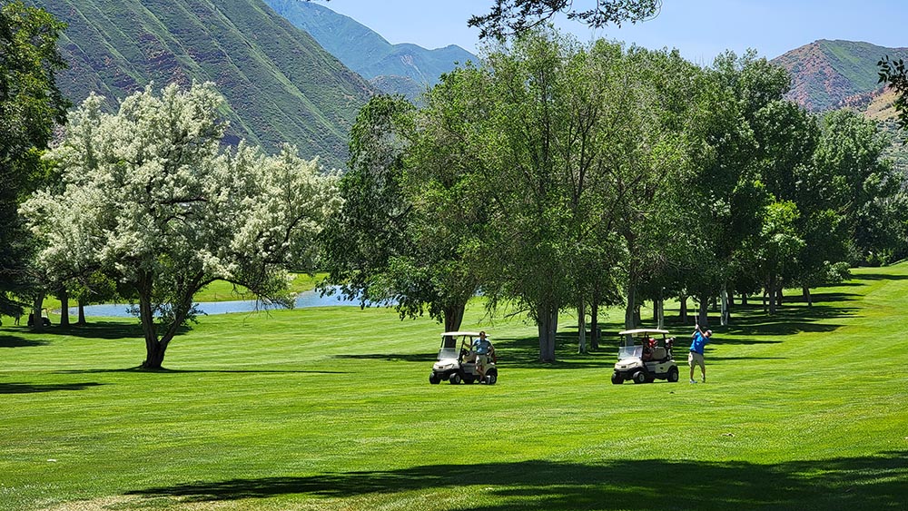Two Golfers and Carts Under Trees at Glenwood Springs Golf Course near Glenwood Hot Springs Resort