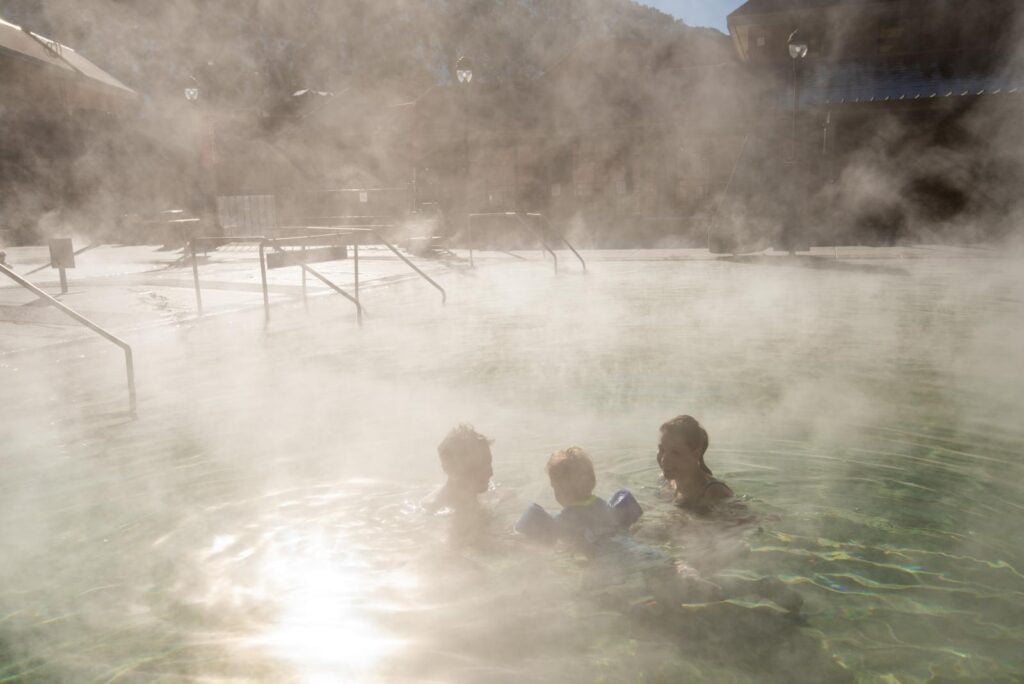 Couple Swimming With Baby in Steaming Pool at Glenwood Hot Springs Resort