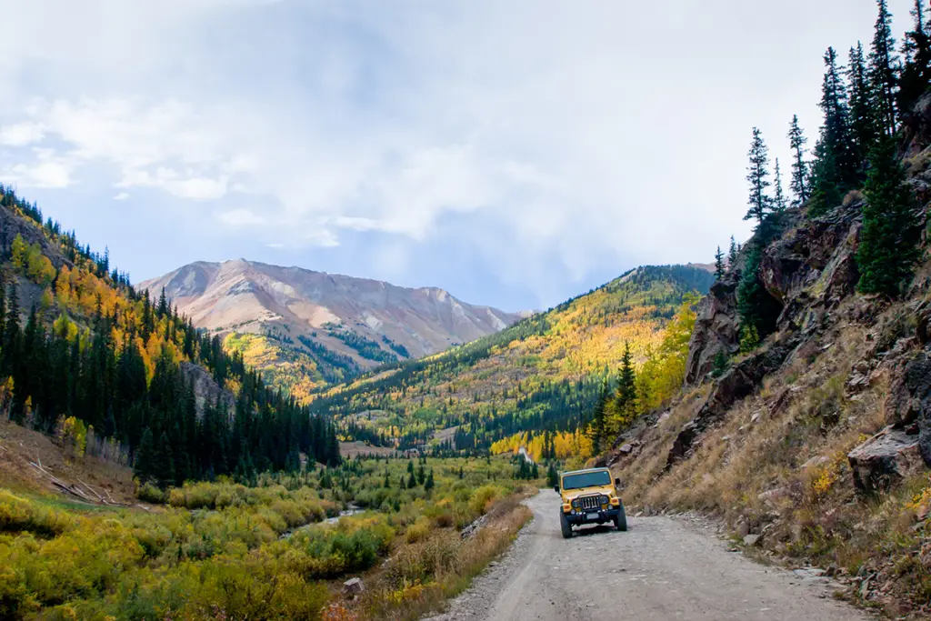 Jeep Climbing Gravel Road with Fall Mountains Behind | Glenwood Hot Springs Resort