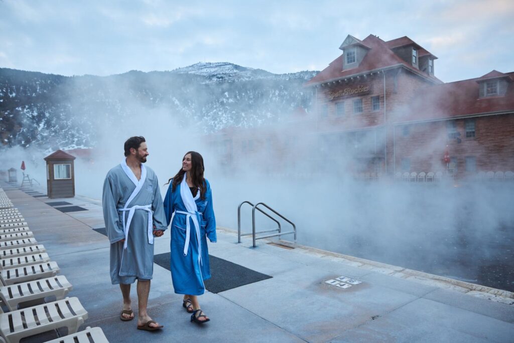 Couple in Robes Walking Hand-in-Hand by Pools at Glenwood Hot Springs Resort