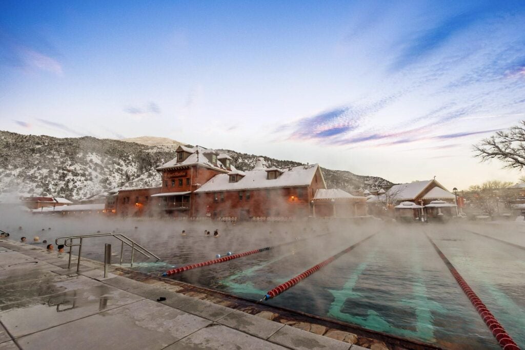Grand Pool swimming lanes with Historic Bath House on a Winter Day at Glenwood Hot Springs Resort