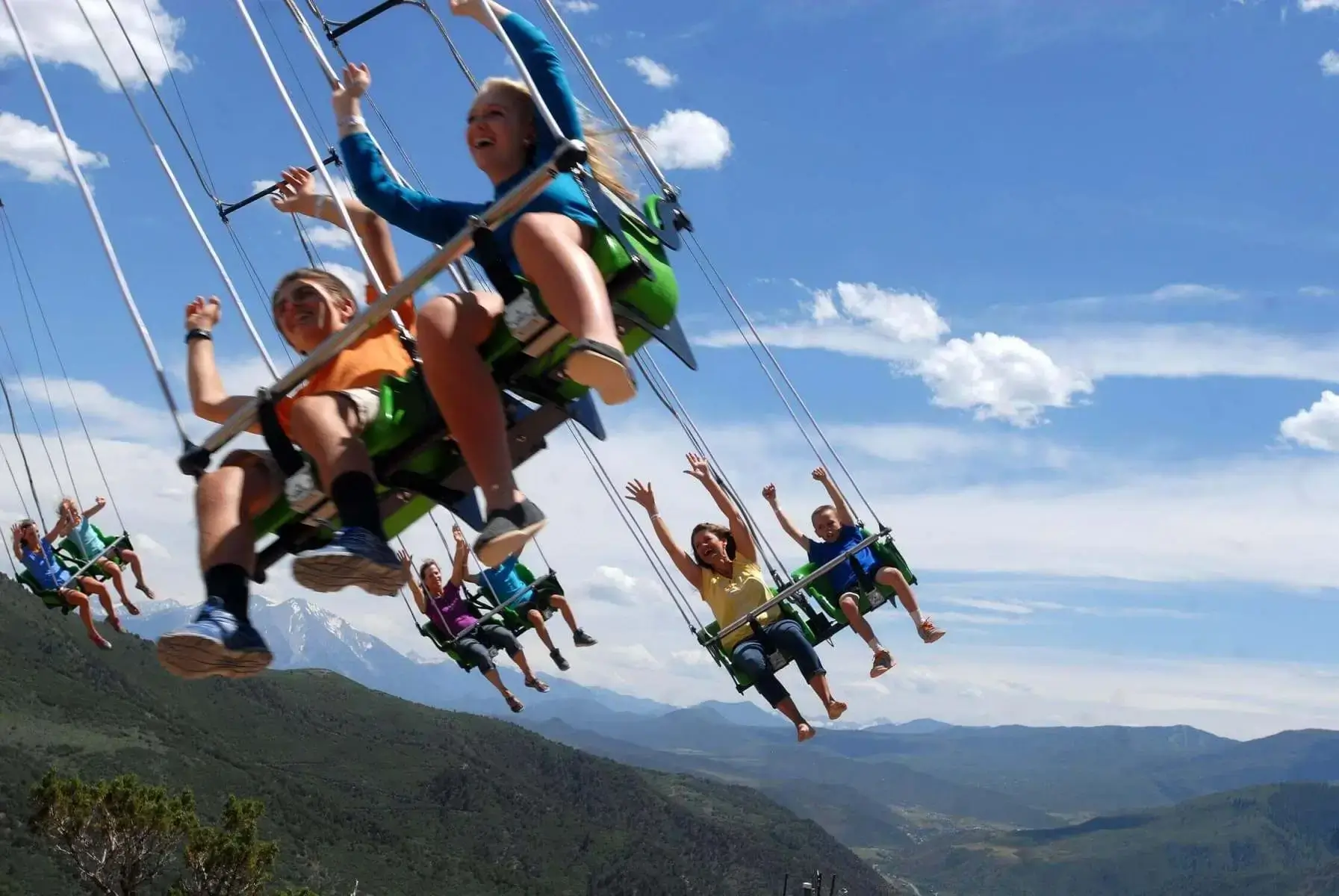 Riders with arms up on the Canyon Flyer at Glenwood Canyons Adventure Park near Glenwood Hot Springs Resort