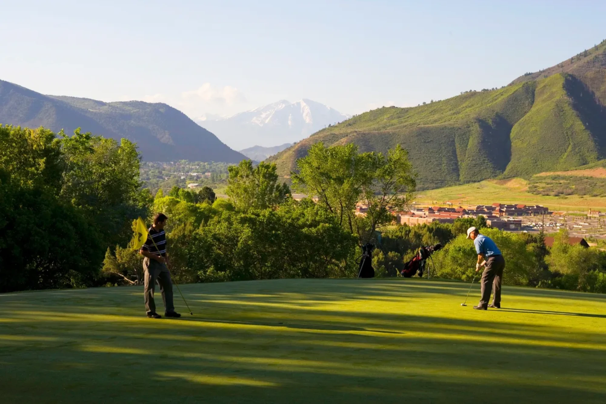 Two men golfing with Mount Sopris in the distance near Glenwood Hot Springs Resort