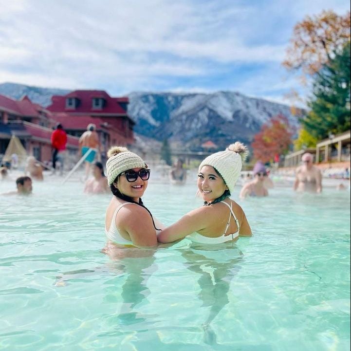Two women with ski hats in the Grand Pool at Glenwood Hot Springs Resort