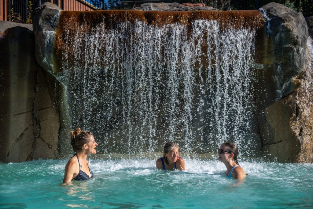 Three women chatting in Falling Waters of Yampah Mineral Baths at Glenwood Hot Springs Resort